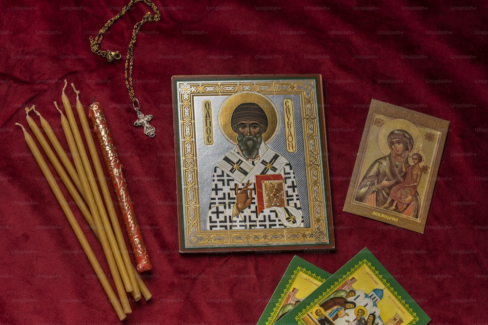 a picture of a saint with a rosary, incense sticks, and other items