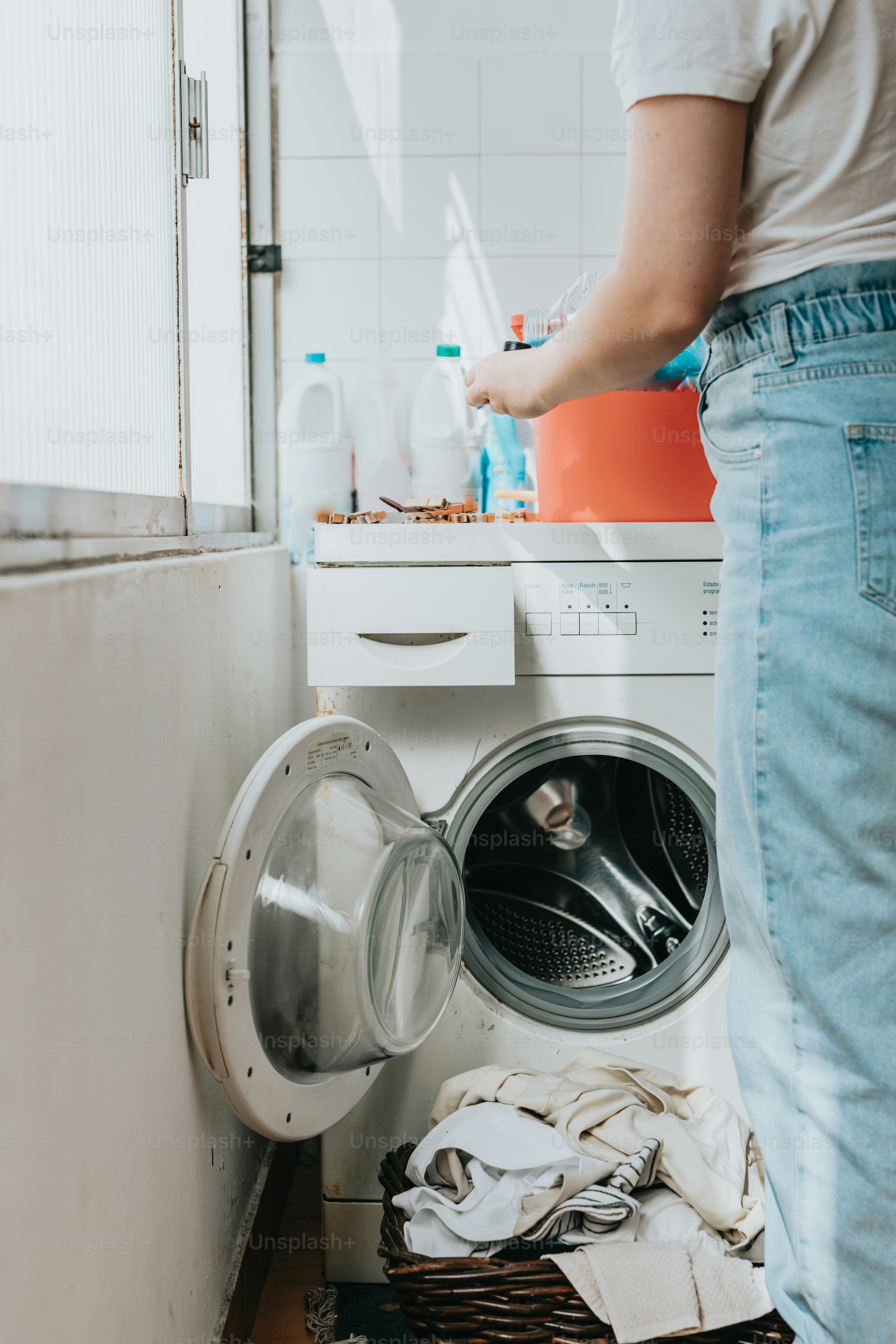 A person standing in front of a washing machine photo – Cleaning Image ...