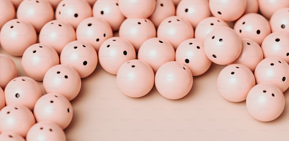 a group of pink balls with black dots on them