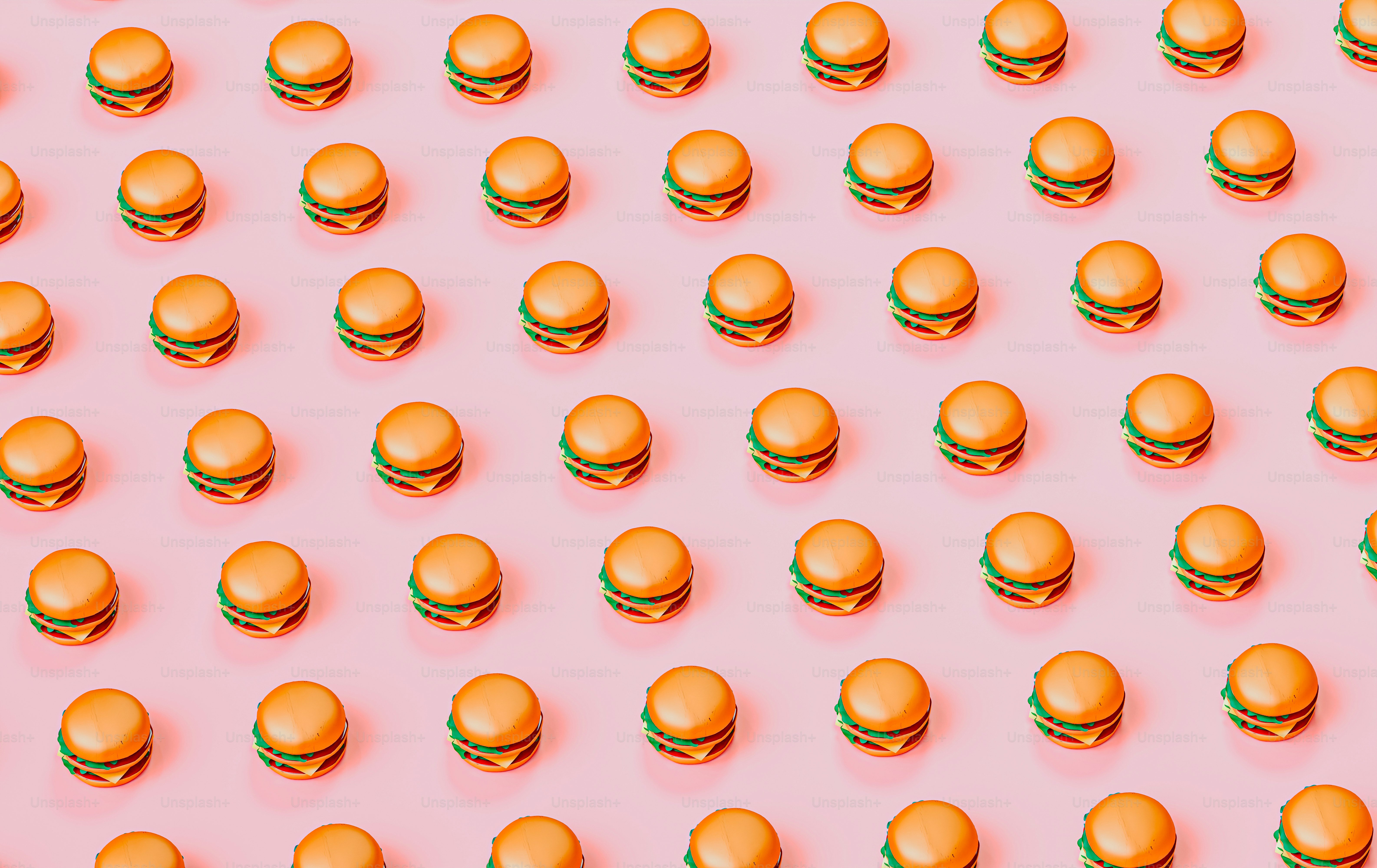 a lot of hamburgers that are on a pink surface