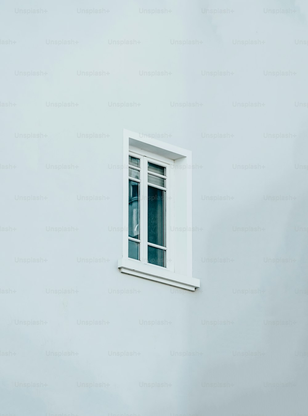 una finestra bianca sul lato di un edificio bianco