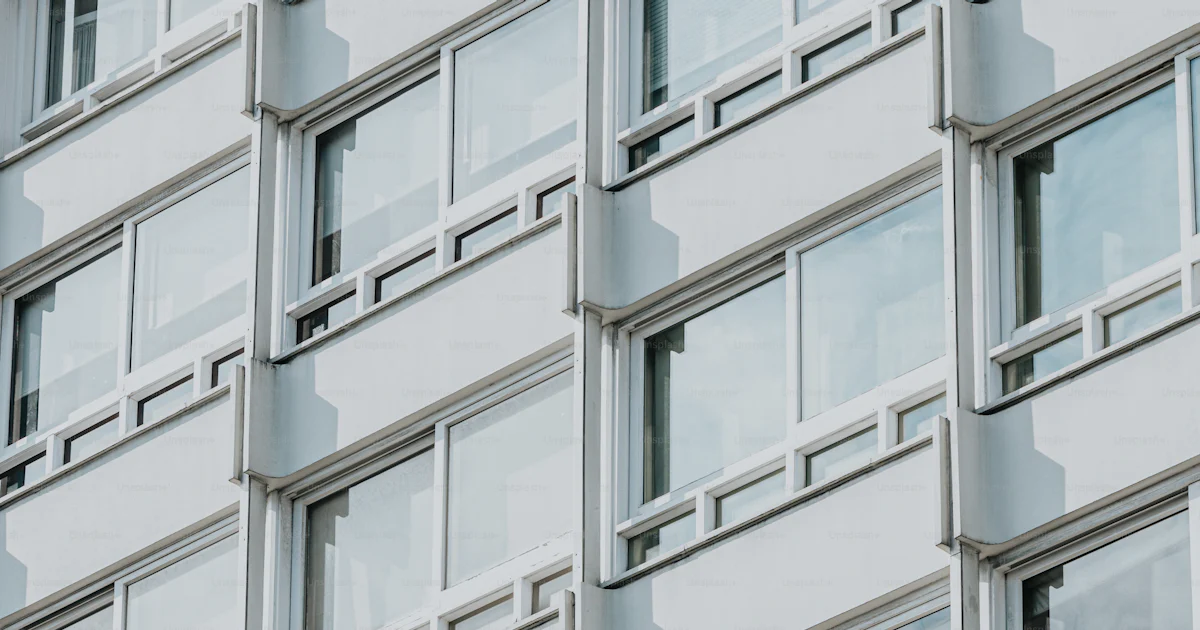 Clock Windows Building A building with many windows and a clock on the side of it photo ...