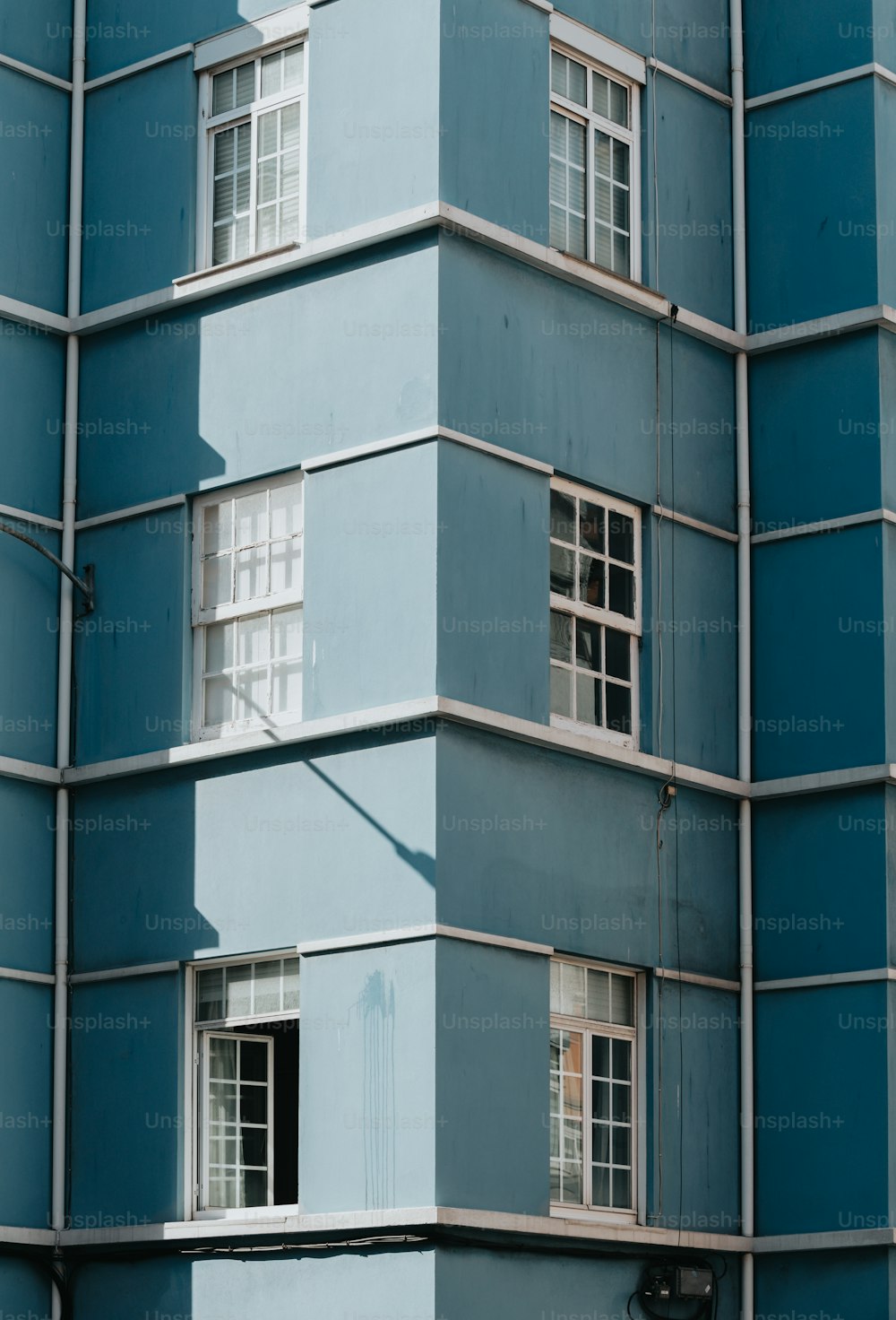 un alto edificio blu con finestre e un cartello stradale