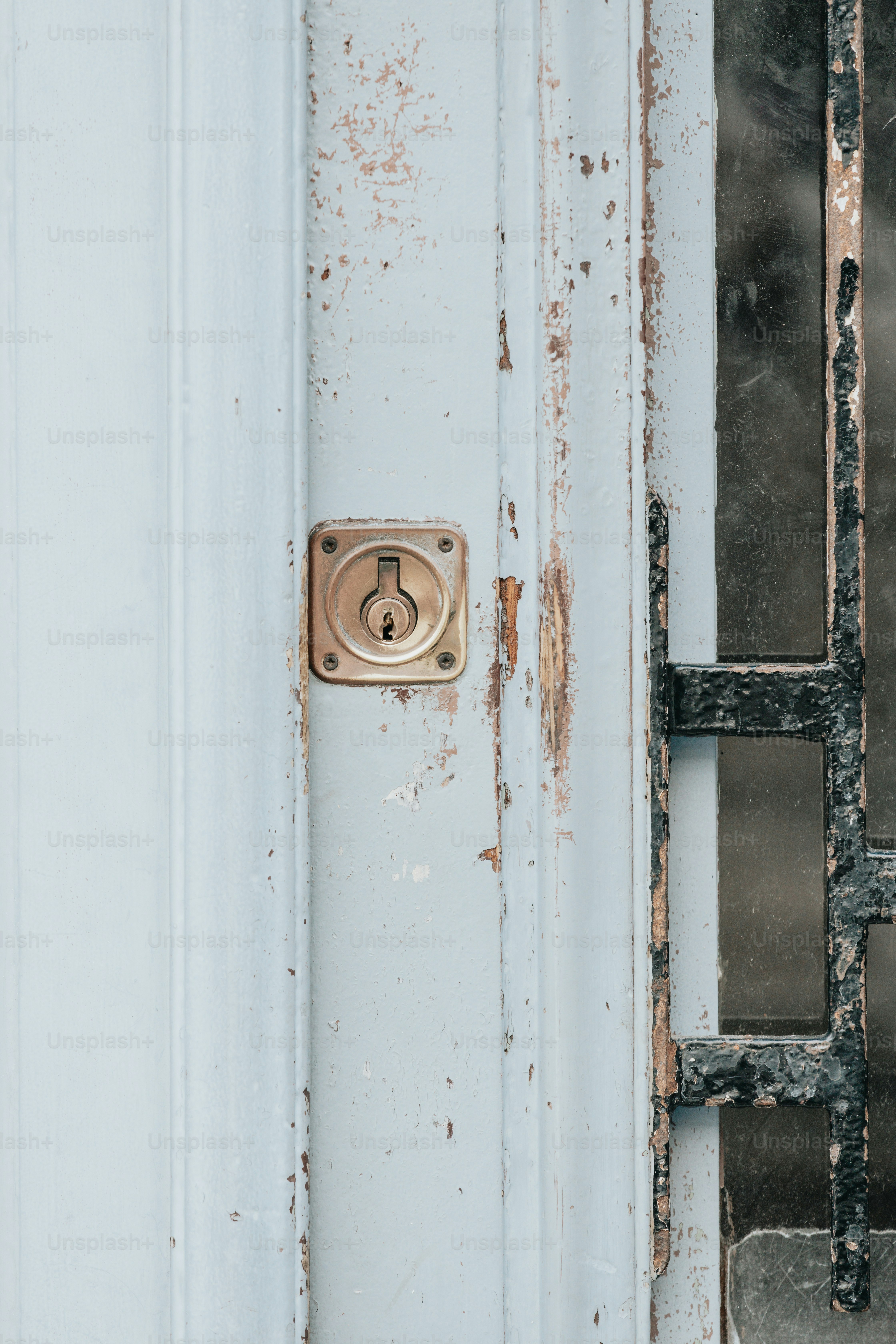 a door handle on a white door with peeling paint