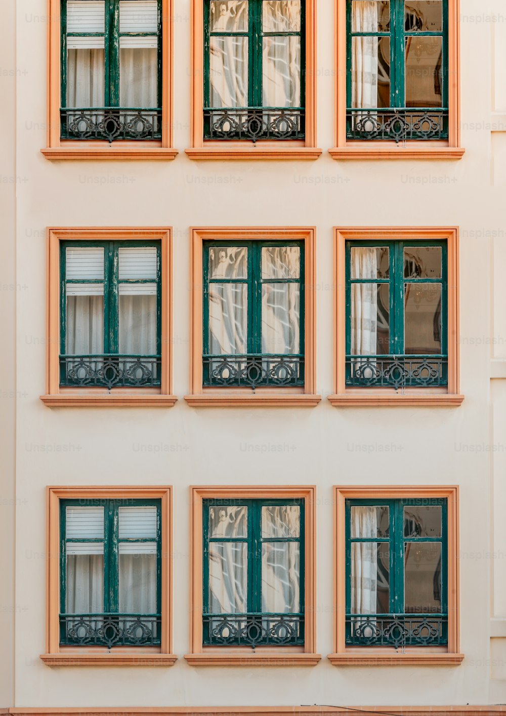 Ein Gebäude mit vielen Fenstern und grünen Fensterläden