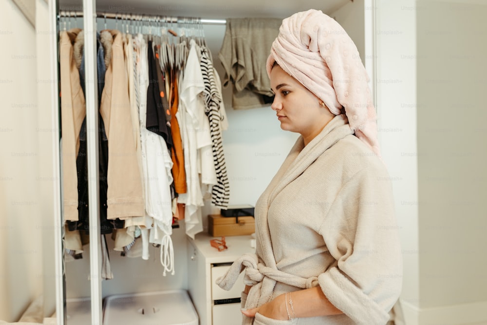 a woman standing in front of a closet full of clothes