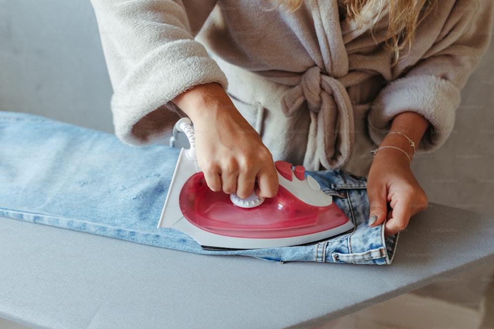 Woman Ironing Cloth With Electric Iron Stock Photo