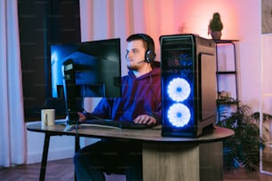 a man sitting in front of a computer on a desk