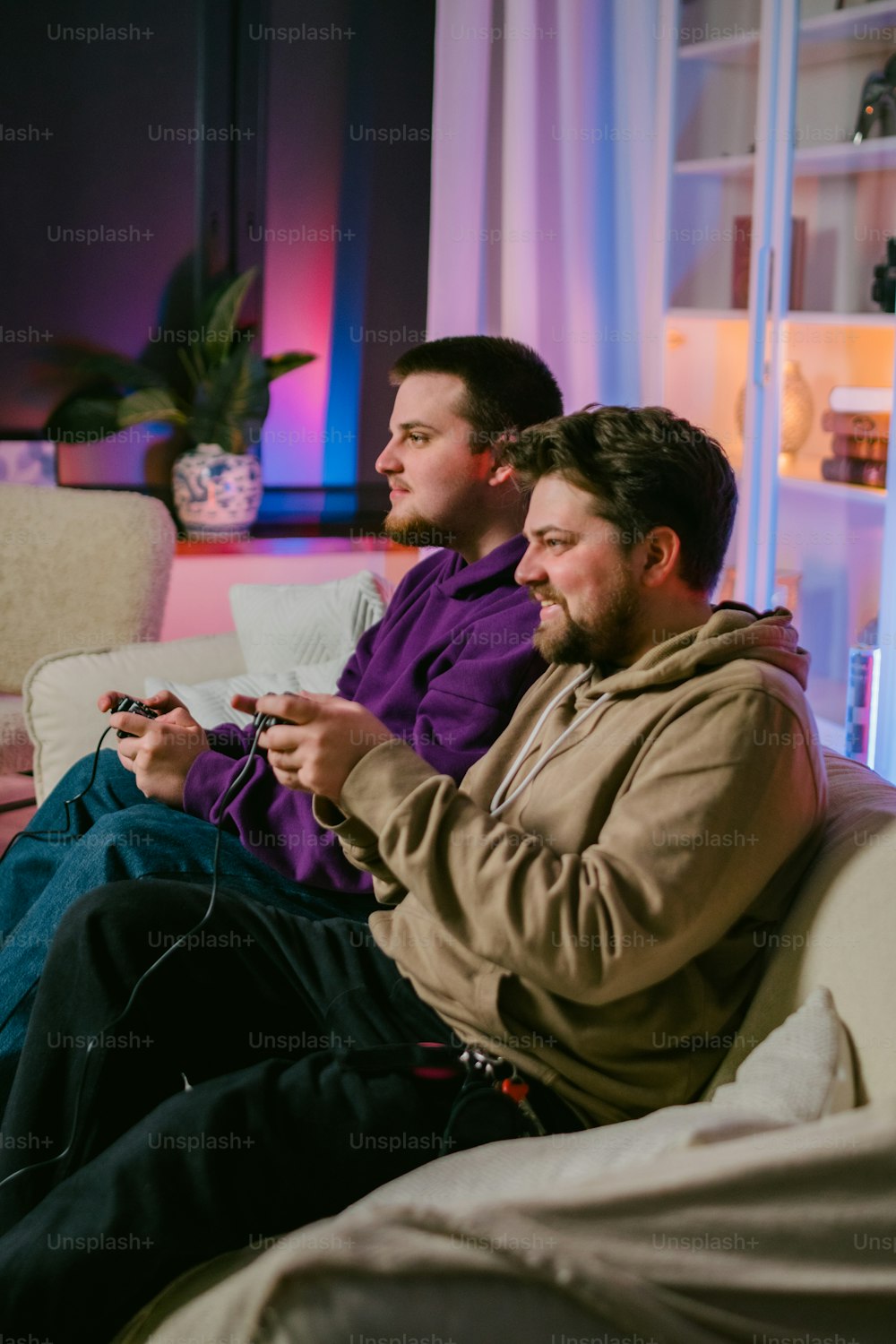 a couple of men sitting on top of a couch