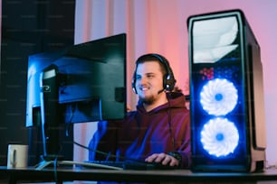 um homem usando fones de ouvido sentado na frente de um computador