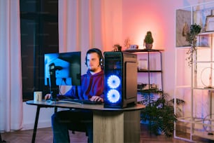 a man sitting in front of a computer monitor