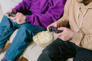 two people sitting on a couch playing video games