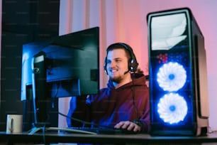 a man wearing headphones sitting in front of a computer