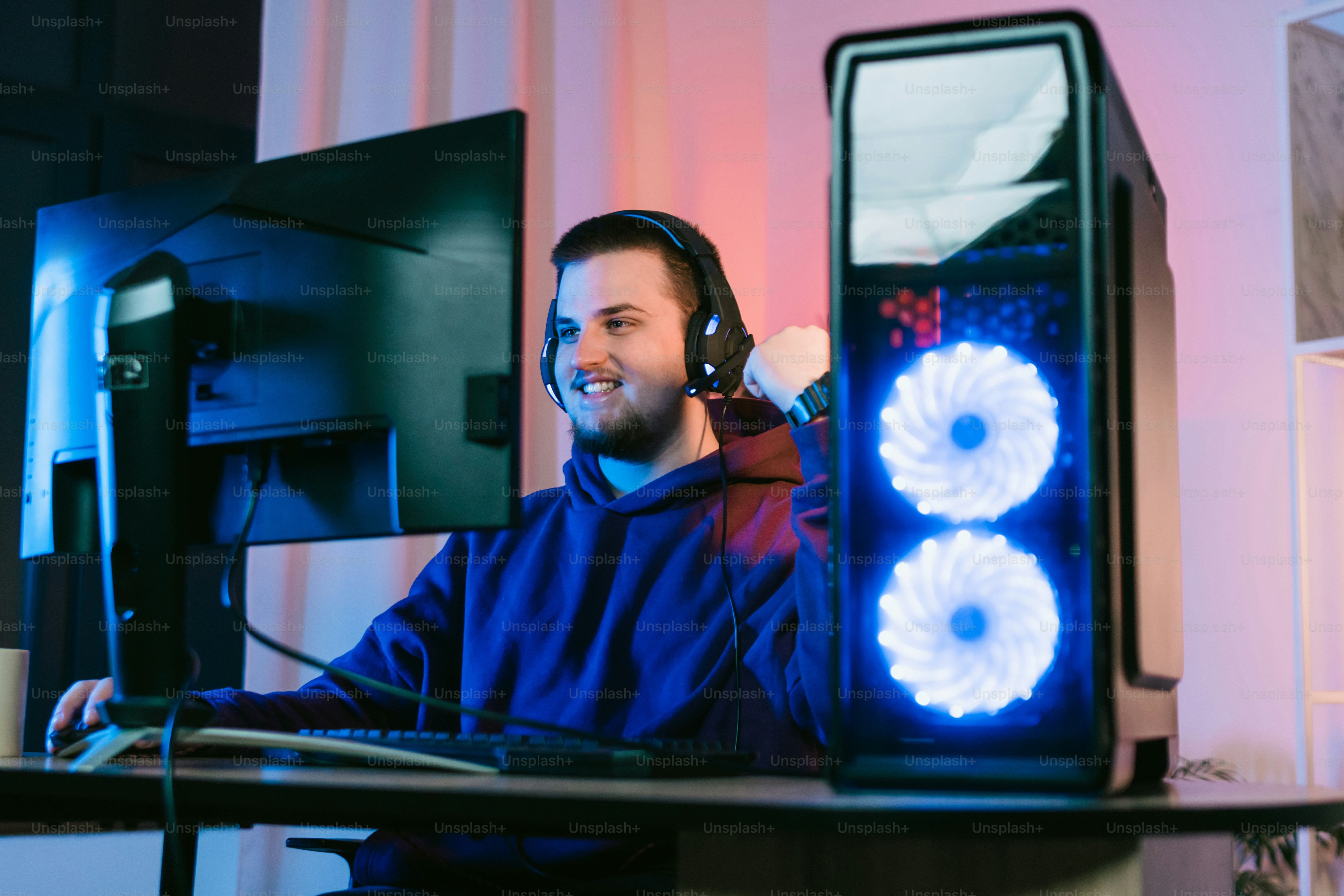 Un hombre sentado frente a una computadora con auriculares puestos