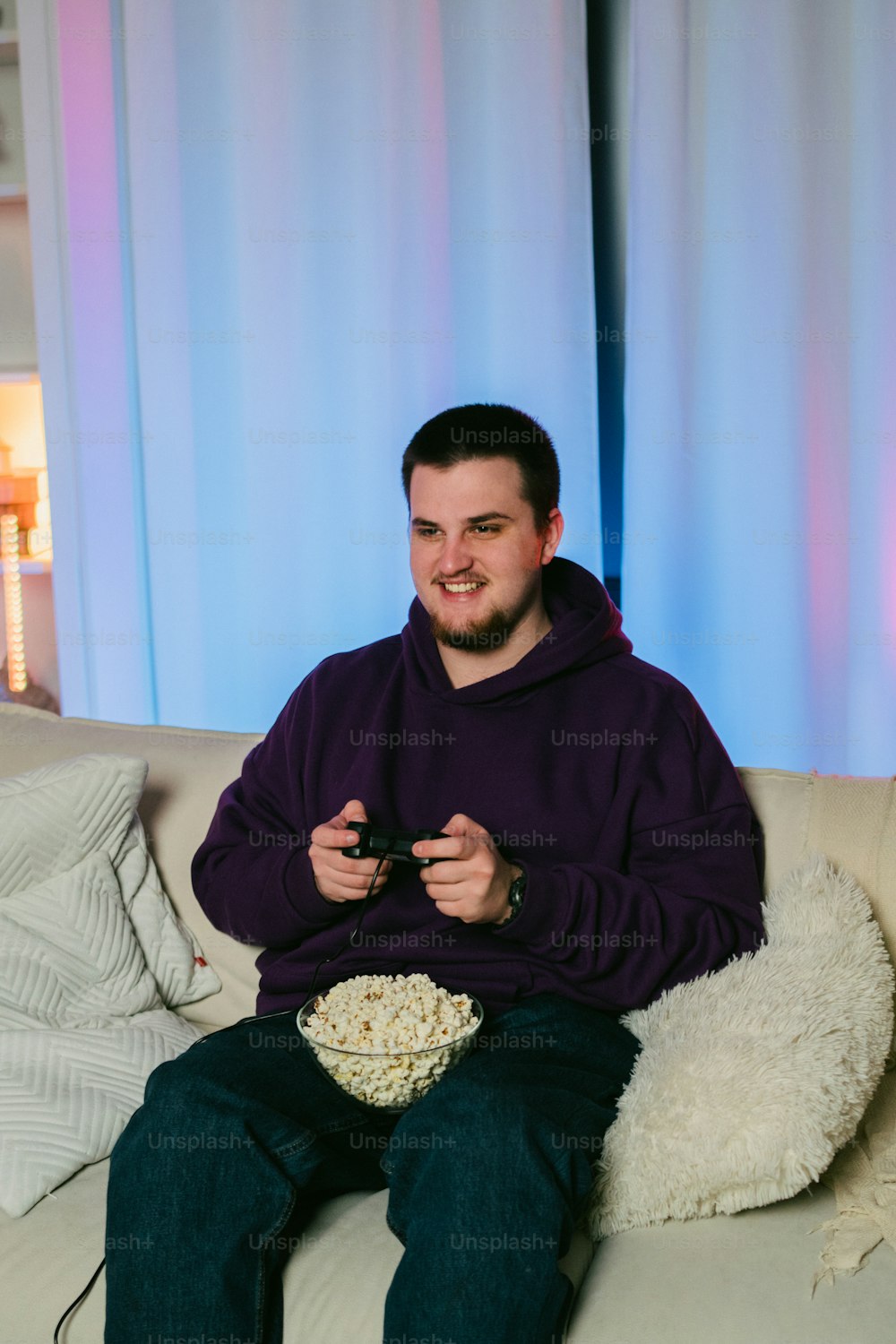 a man sitting on a couch holding a remote control