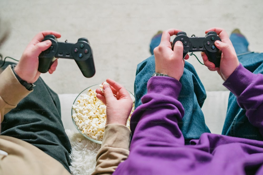 Dos personas sentadas en un sofá jugando un videojuego