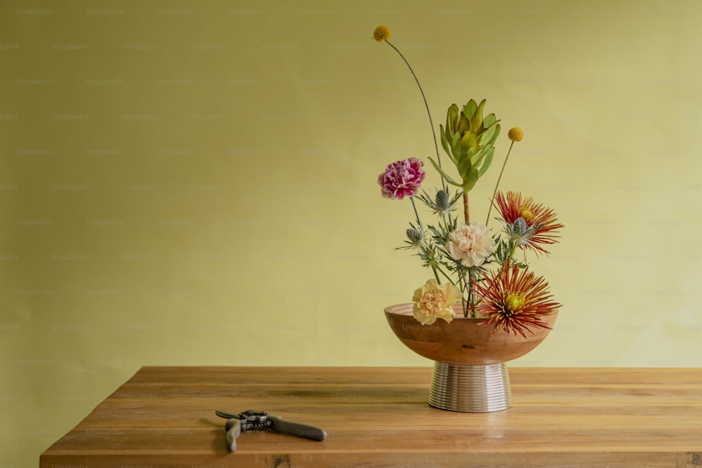 a wooden table topped with a vase filled with flowers