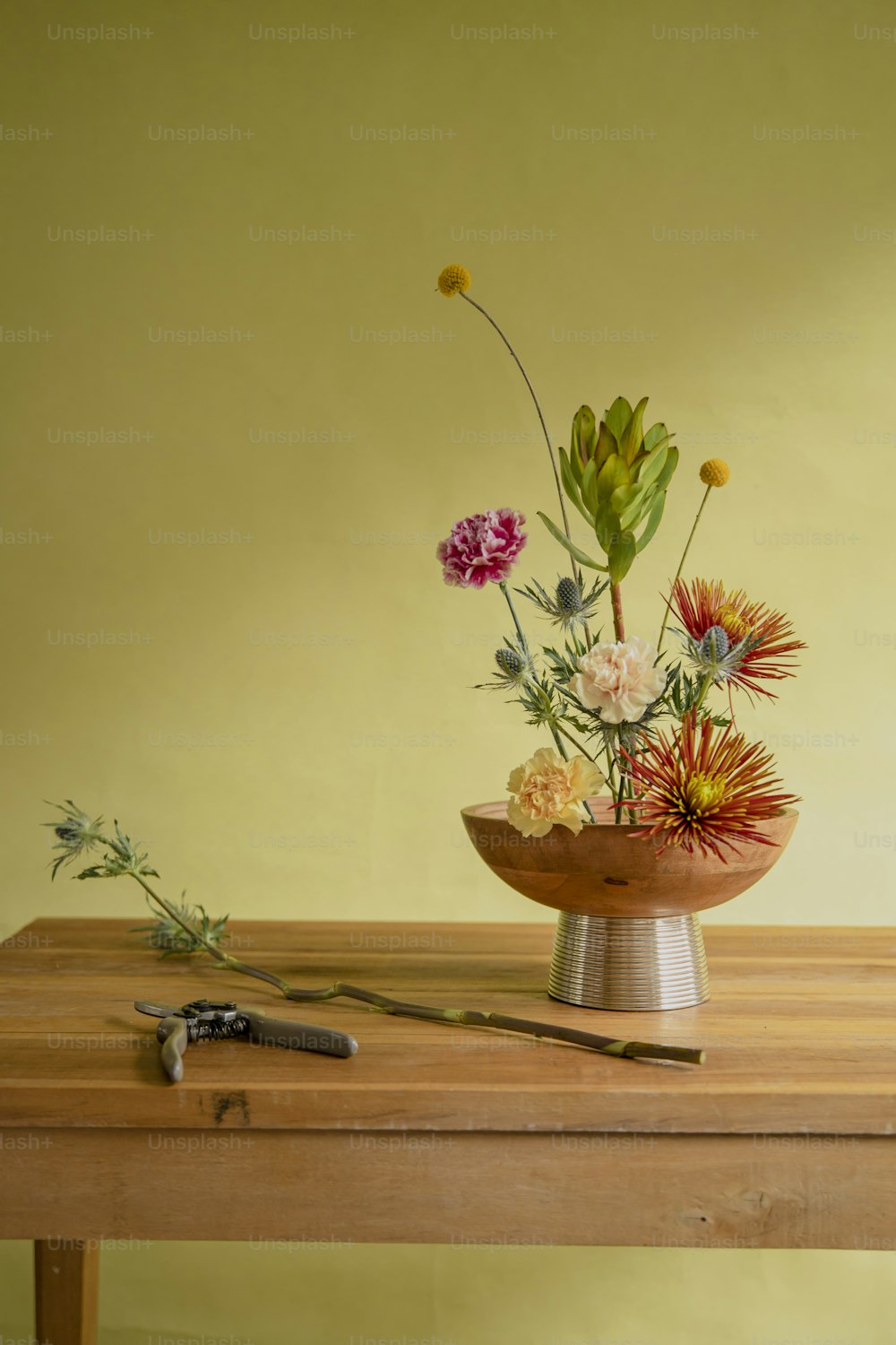 a wooden table topped with a vase filled with flowers