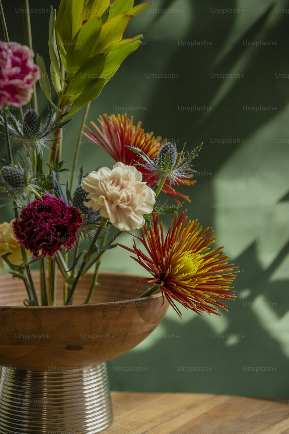 a wooden table topped with a vase filled with flowers