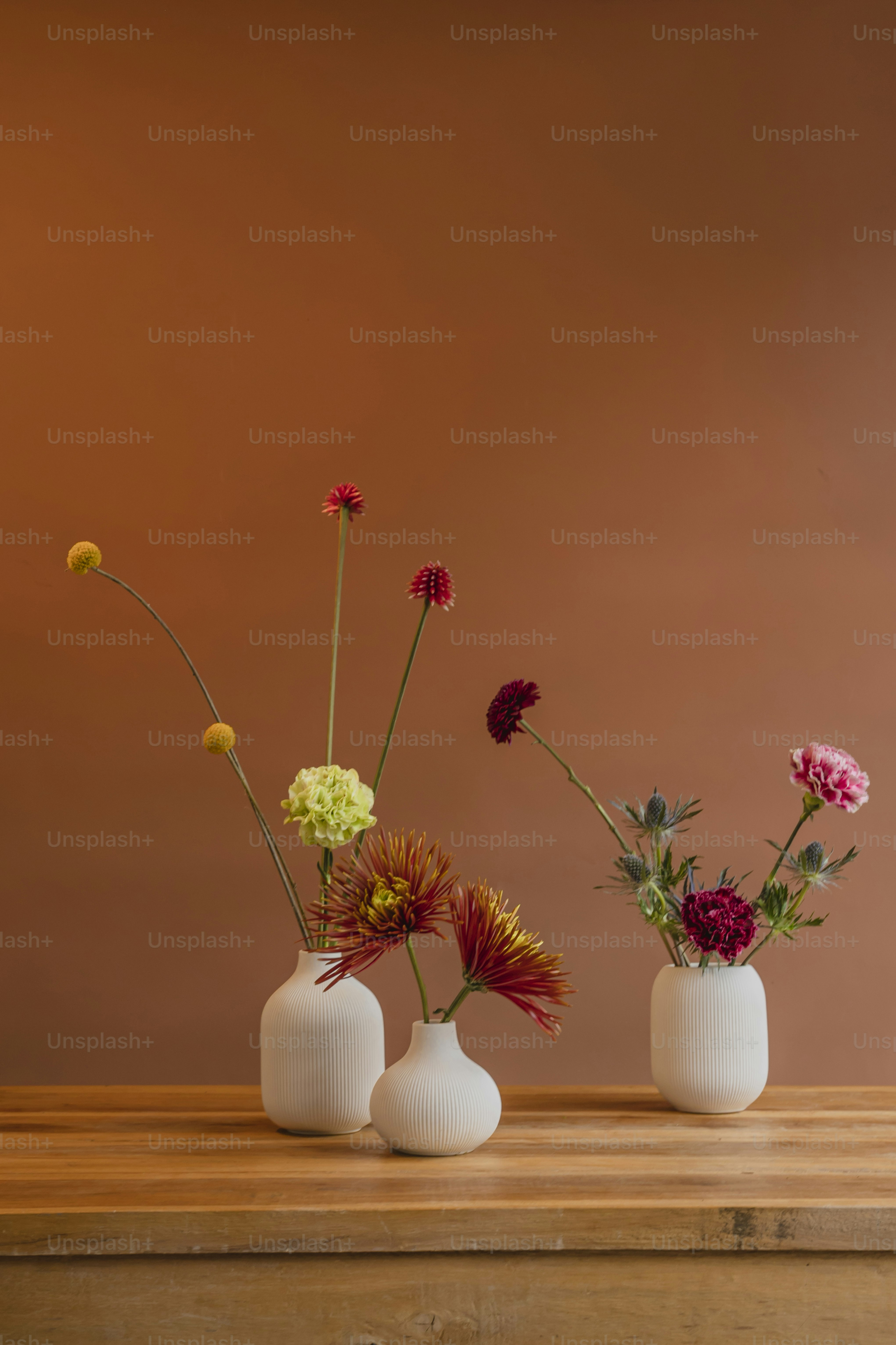 tre vasi bianchi con fiori di colore diverso in essi