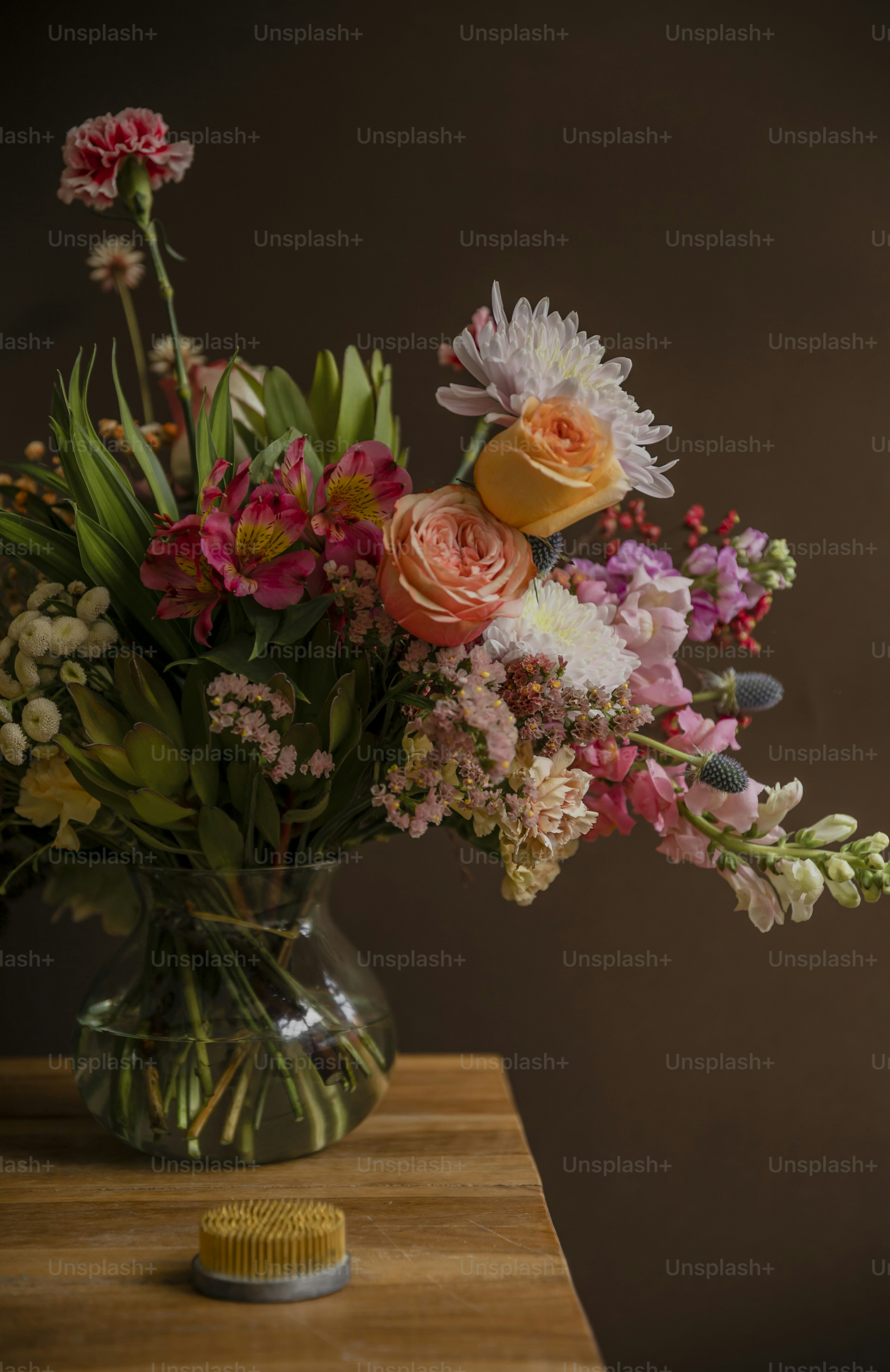 a vase filled with lots of flowers sitting on top of a table