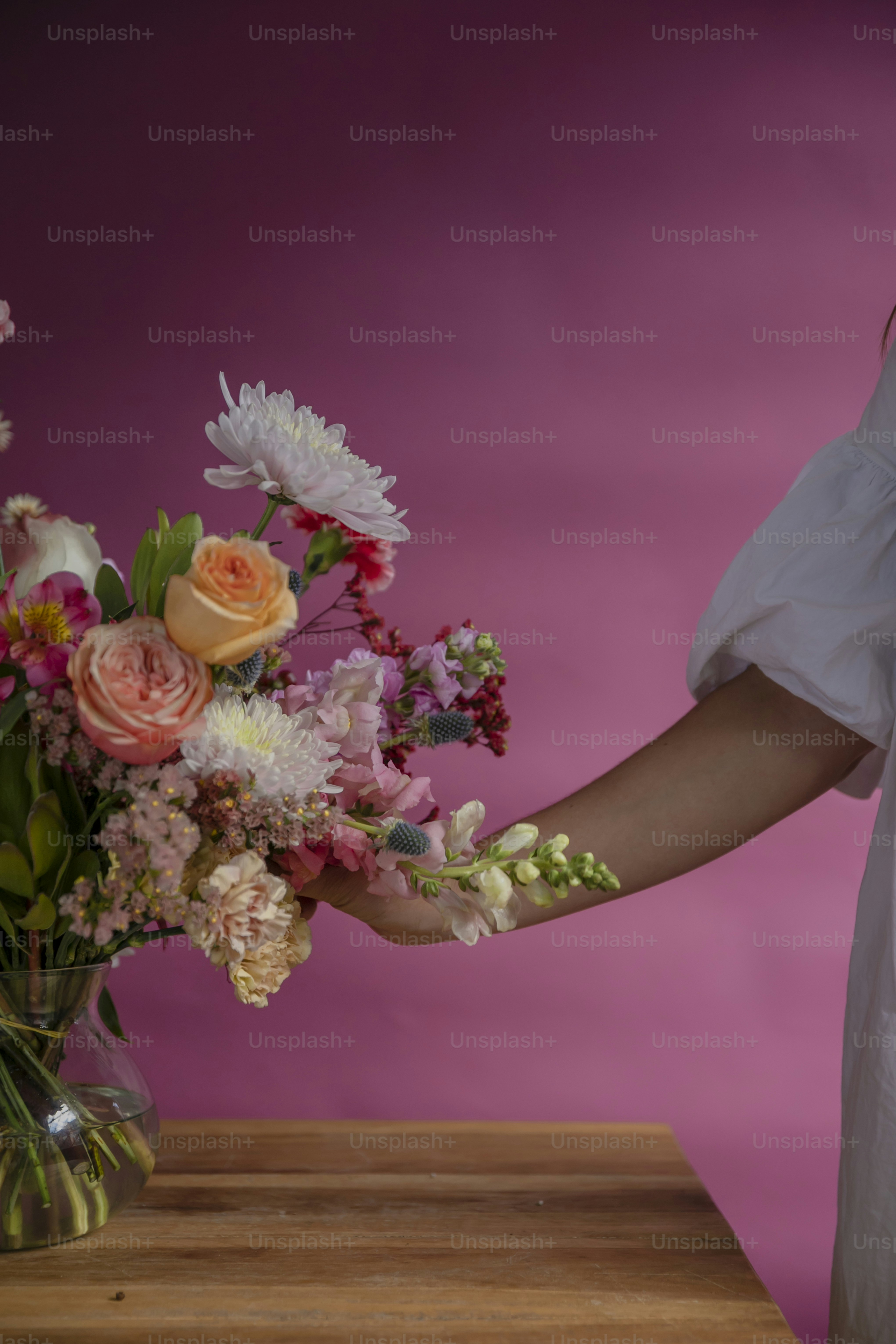 una donna in un vestito bianco che tiene un mazzo di fiori