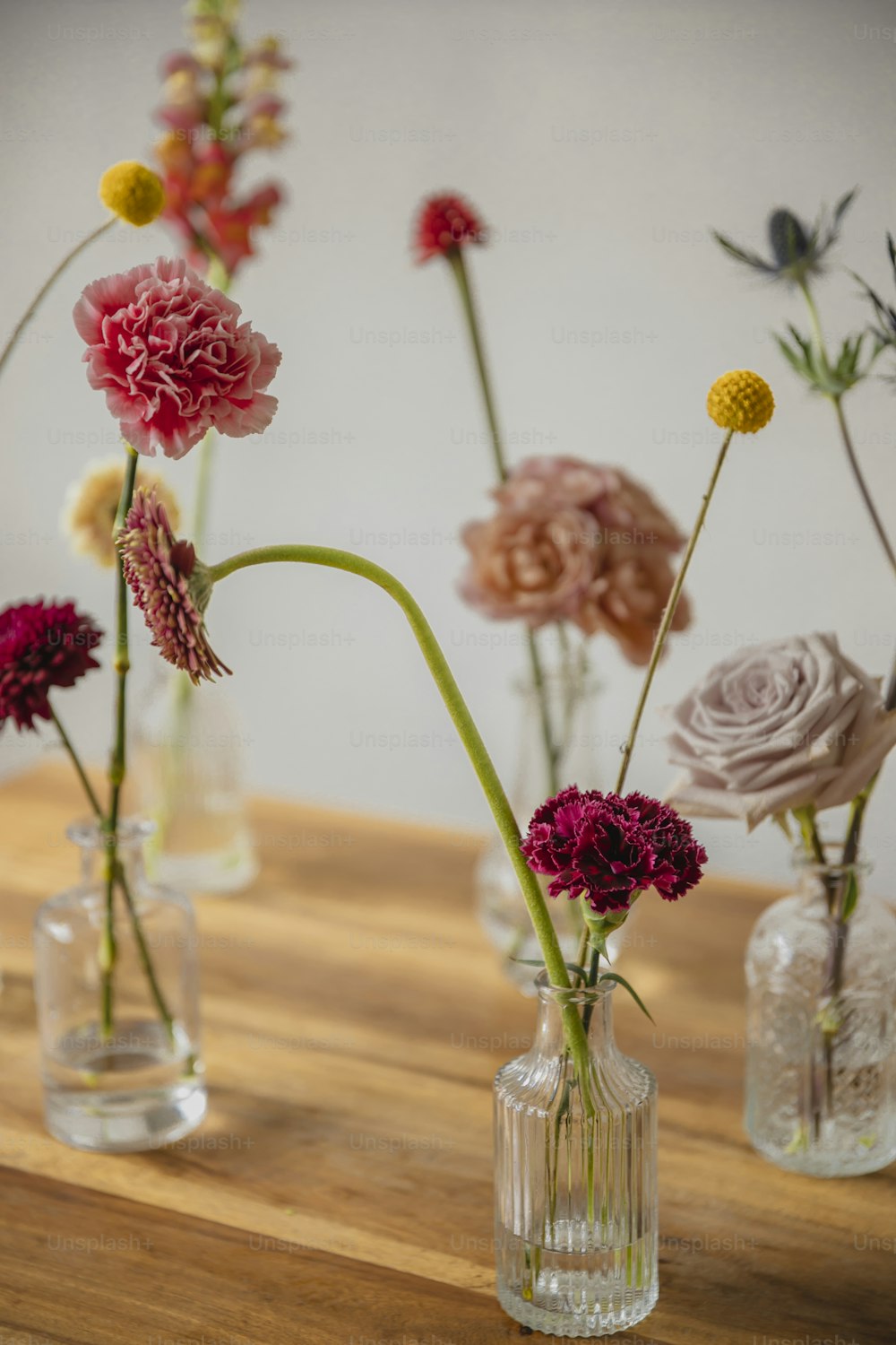 a wooden table topped with vases filled with flowers