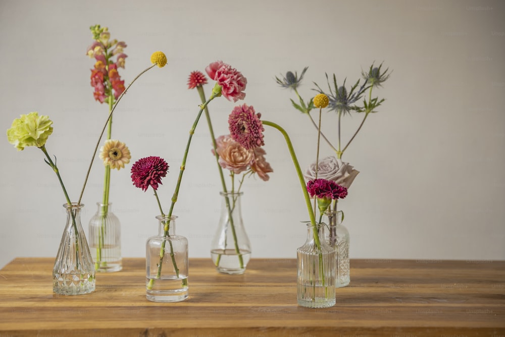 a wooden table topped with vases filled with flowers