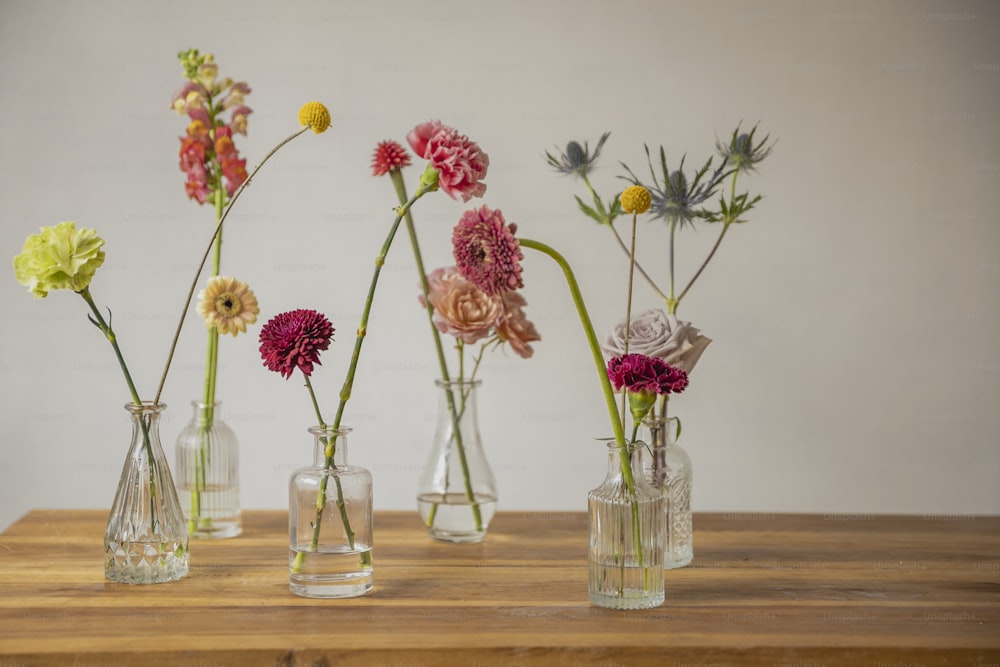ein Holztisch mit Vasen voller Blumen