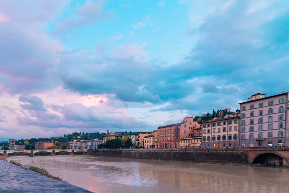 a river running through a city under a cloudy sky