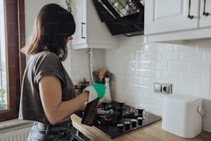 a woman cleaning a stove top in a kitchen