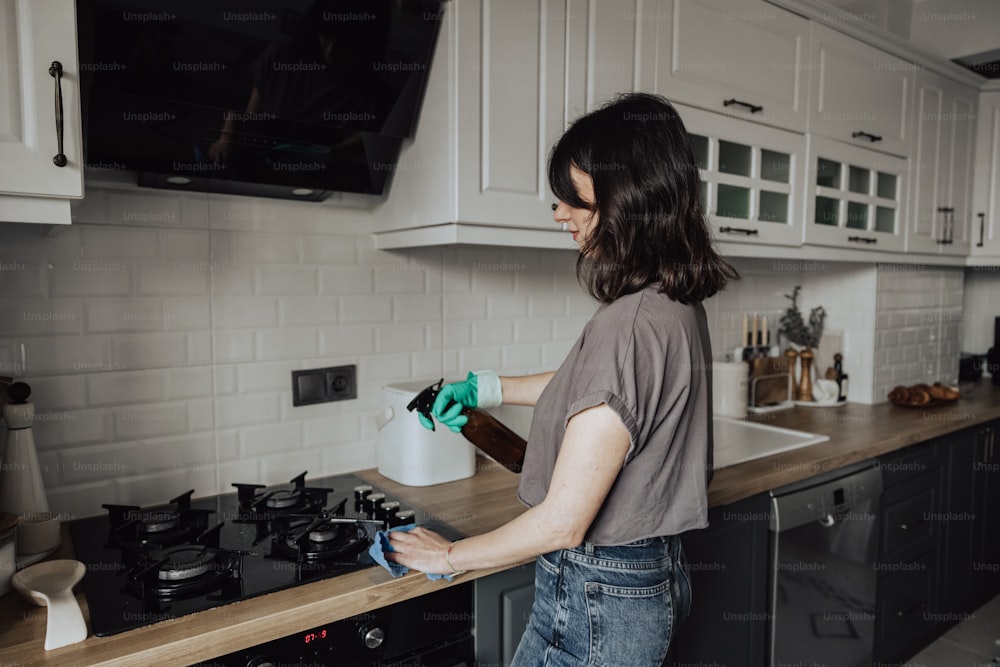 Una mujer limpiando el mostrador de una cocina con un trapo