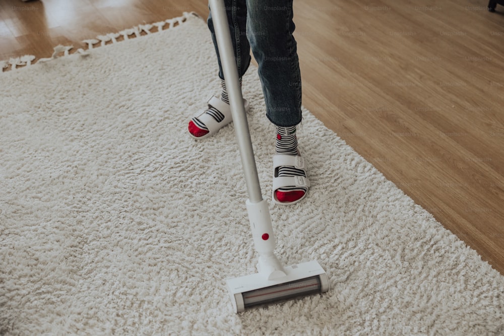 a person using a vacuum cleaner on a carpet