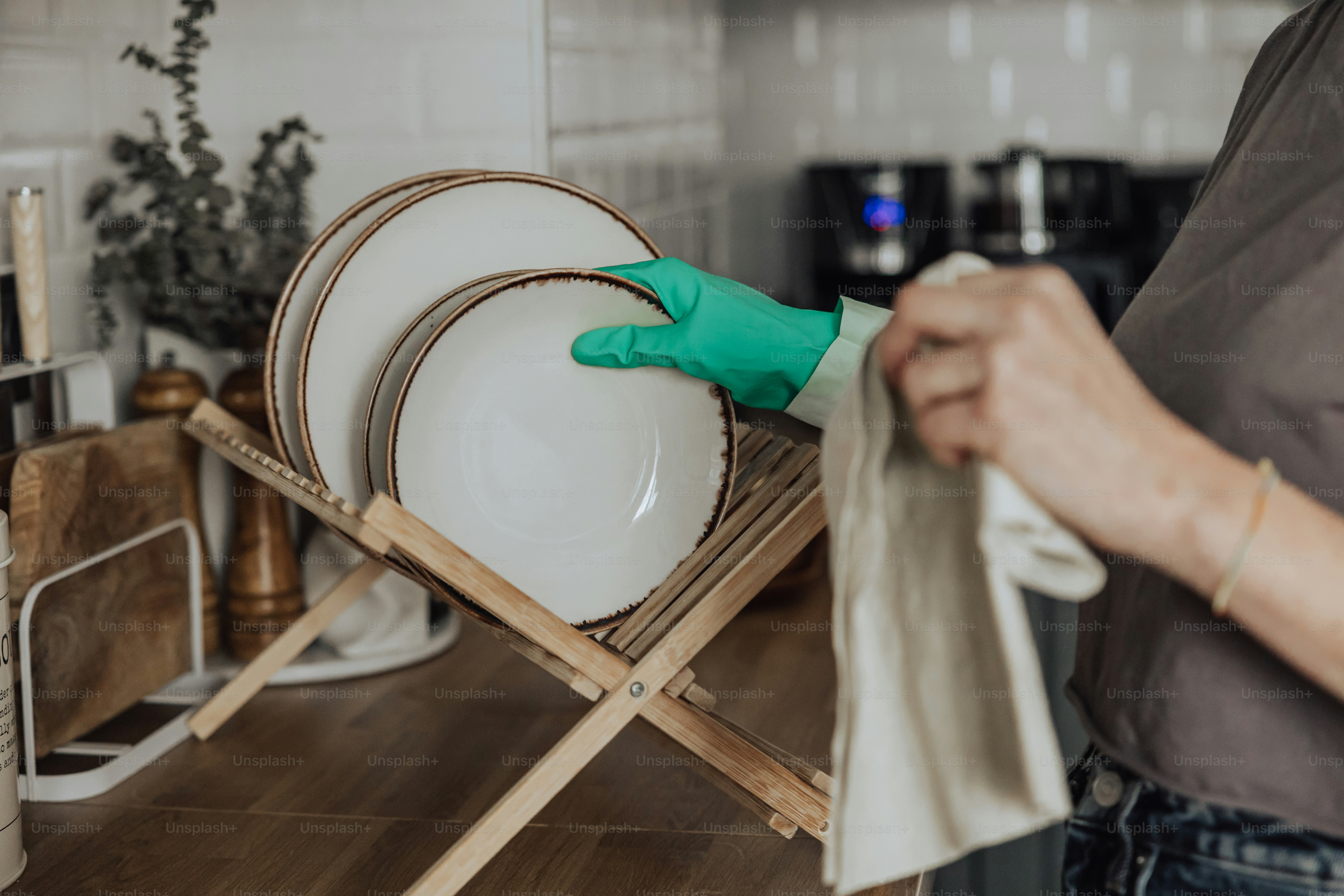 A person in green gloves cleaning dishes on a rack photo – Cleaning ...