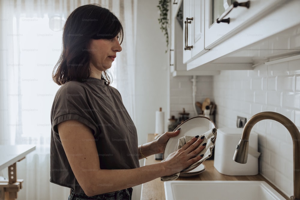 a woman is holding a plate in a kitchen