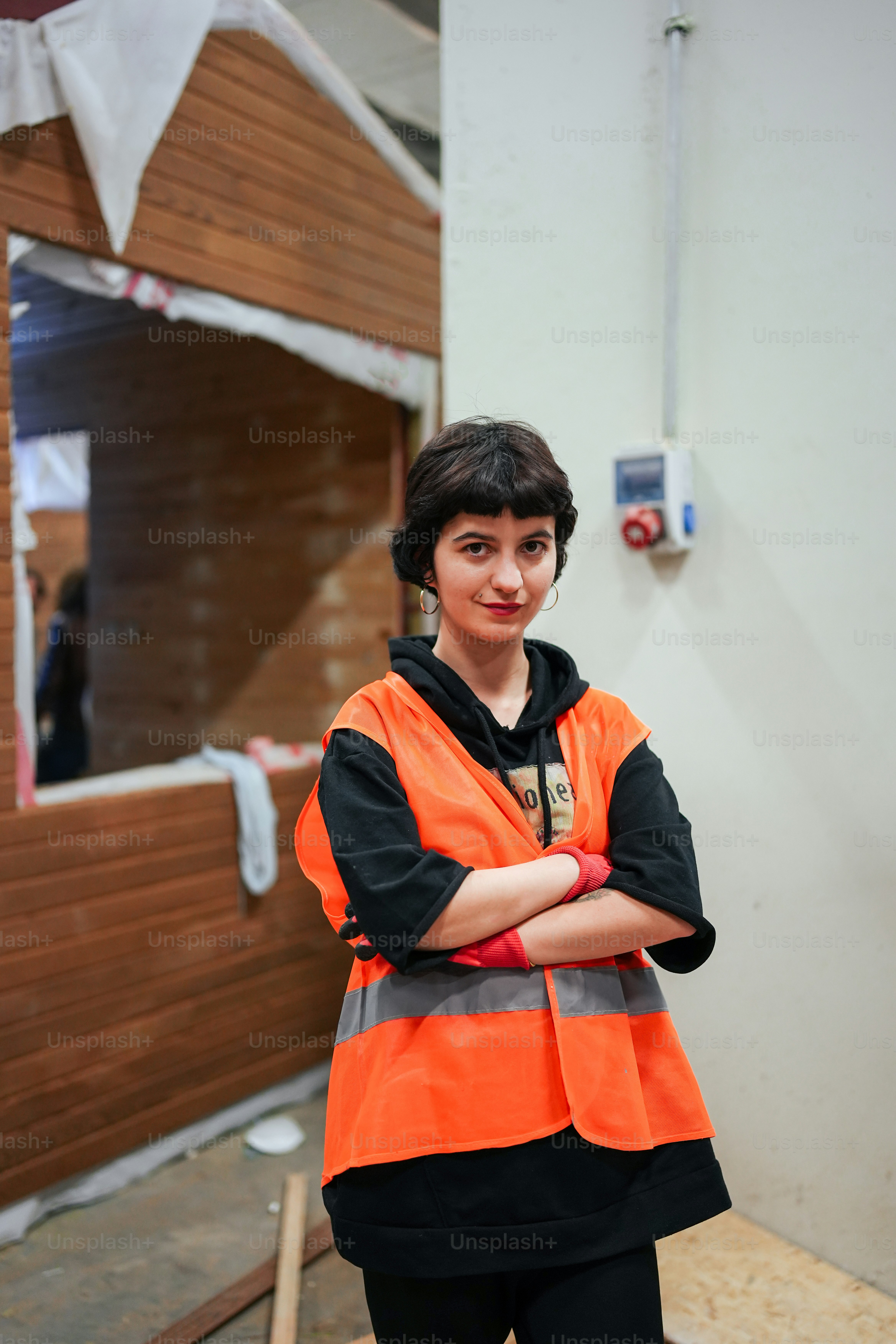 a woman in an orange vest standing in front of a building