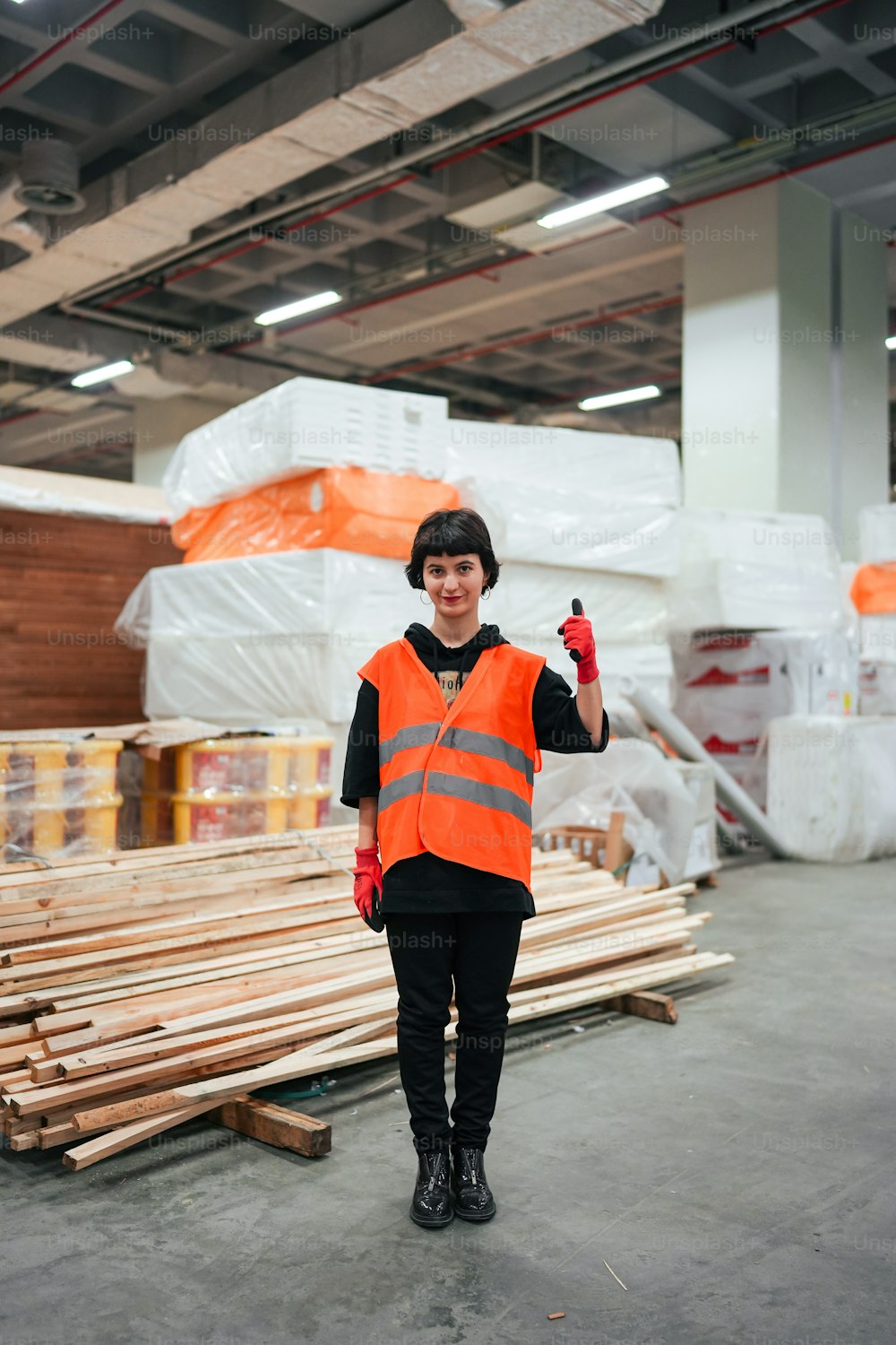 a man in an orange vest standing in a warehouse