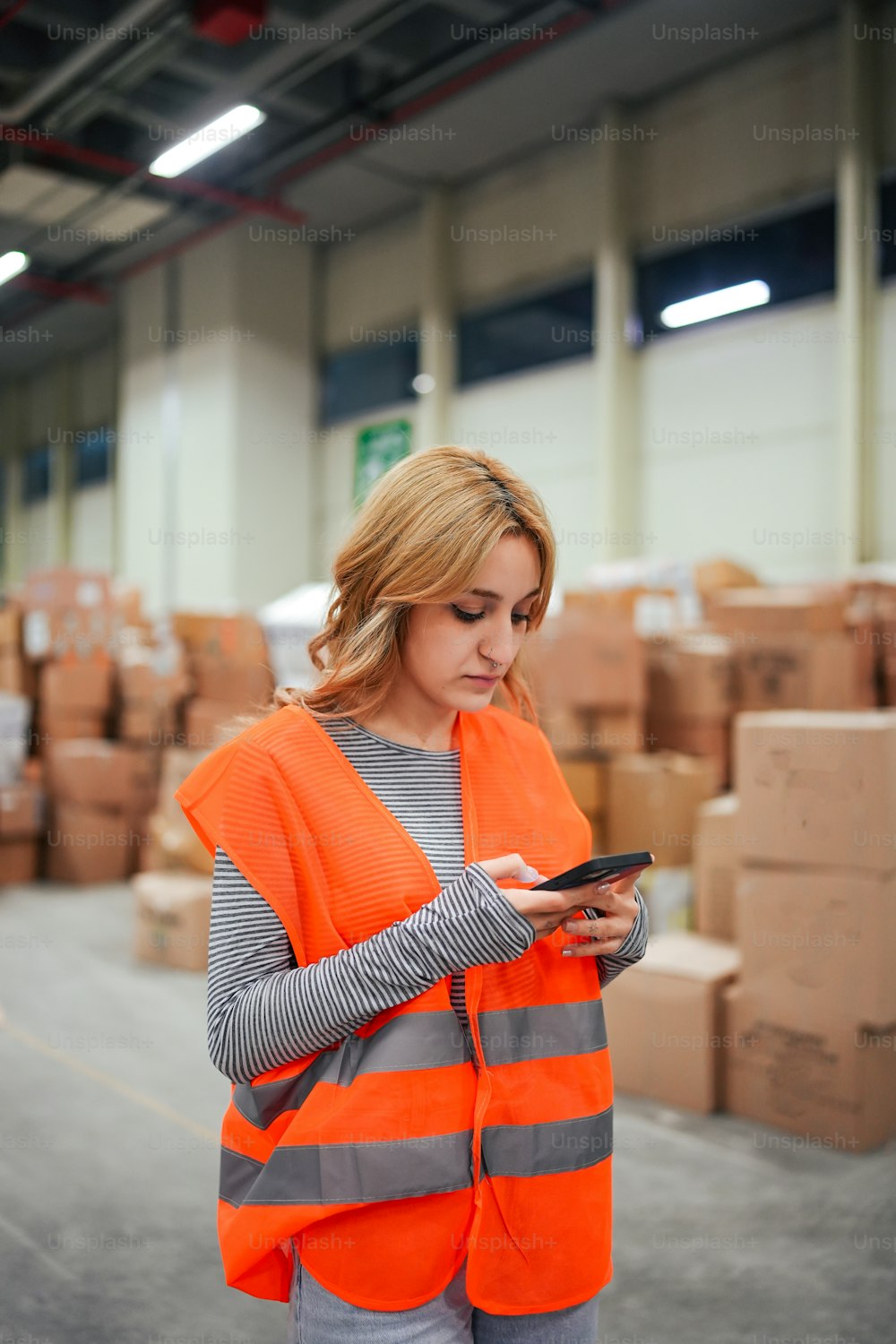 a woman in an orange vest looking at a tablet