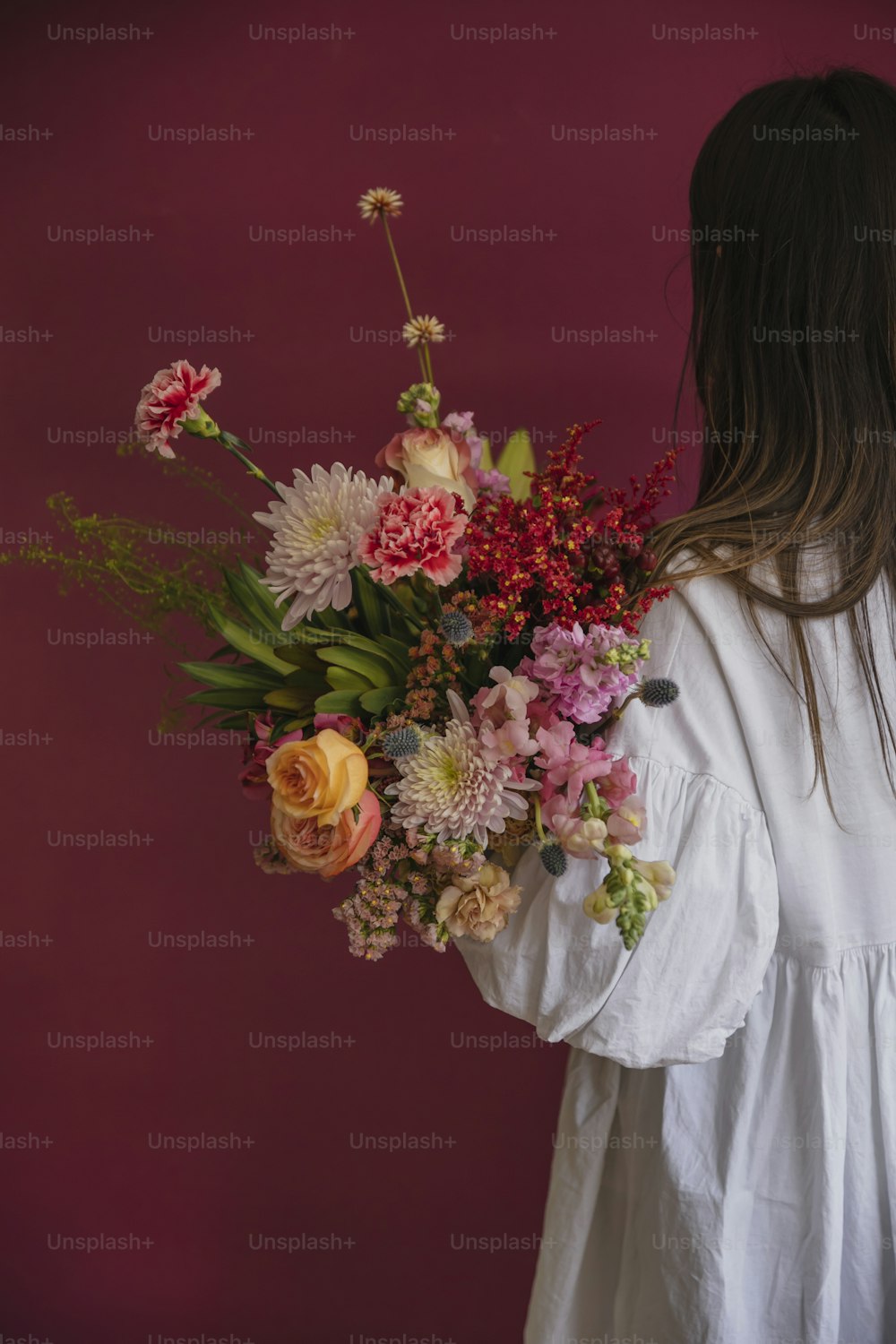 a woman holding a bouquet of flowers in her hands