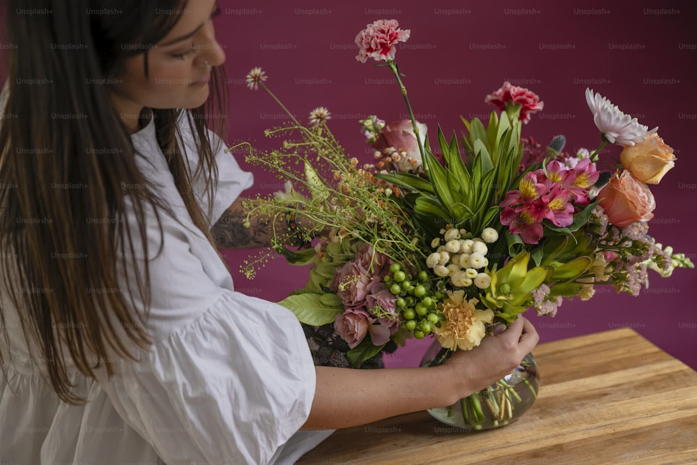 a woman holding a bouquet of flowers on a table