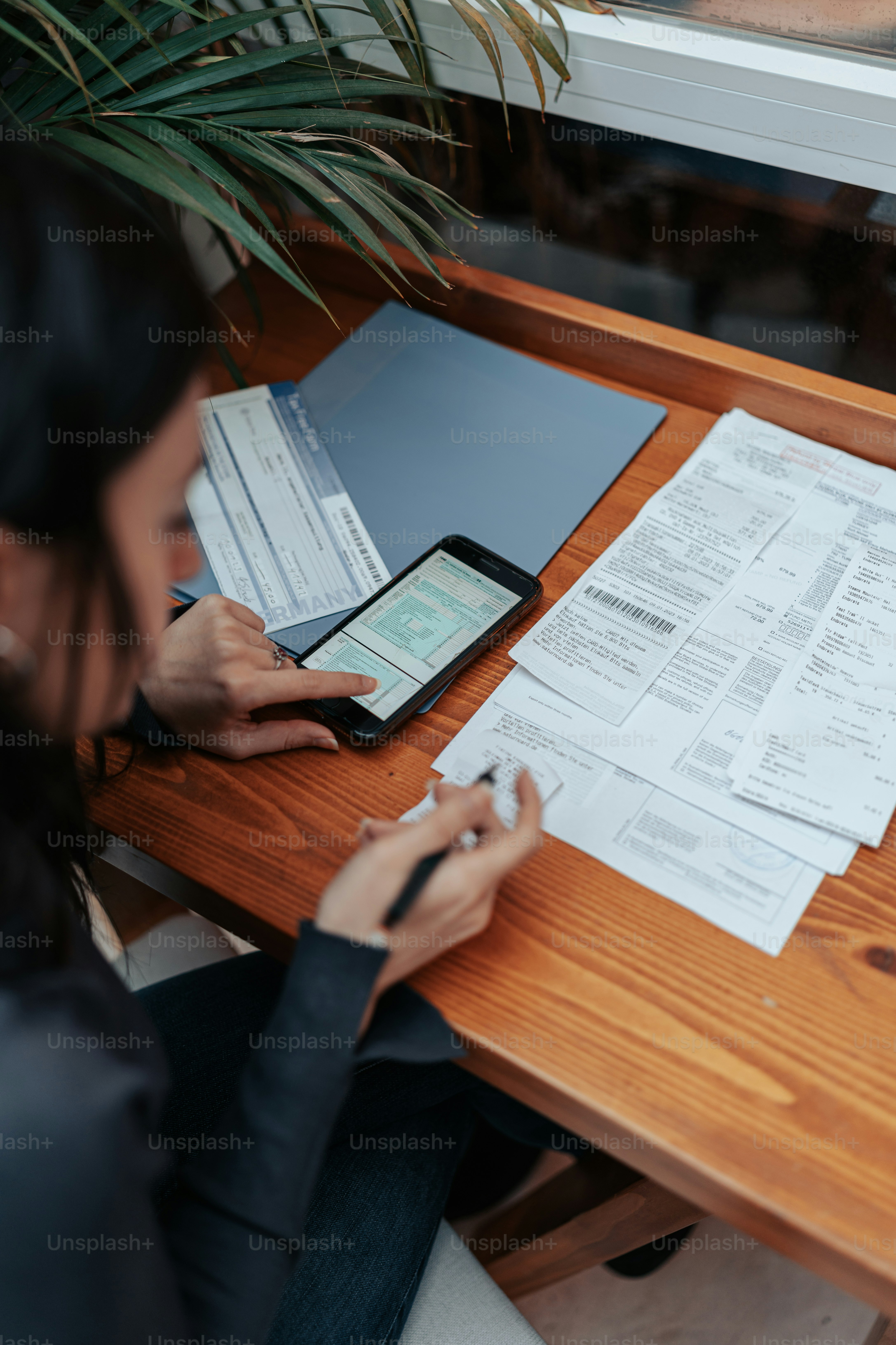 une femme assise à une table avec un téléphone portable