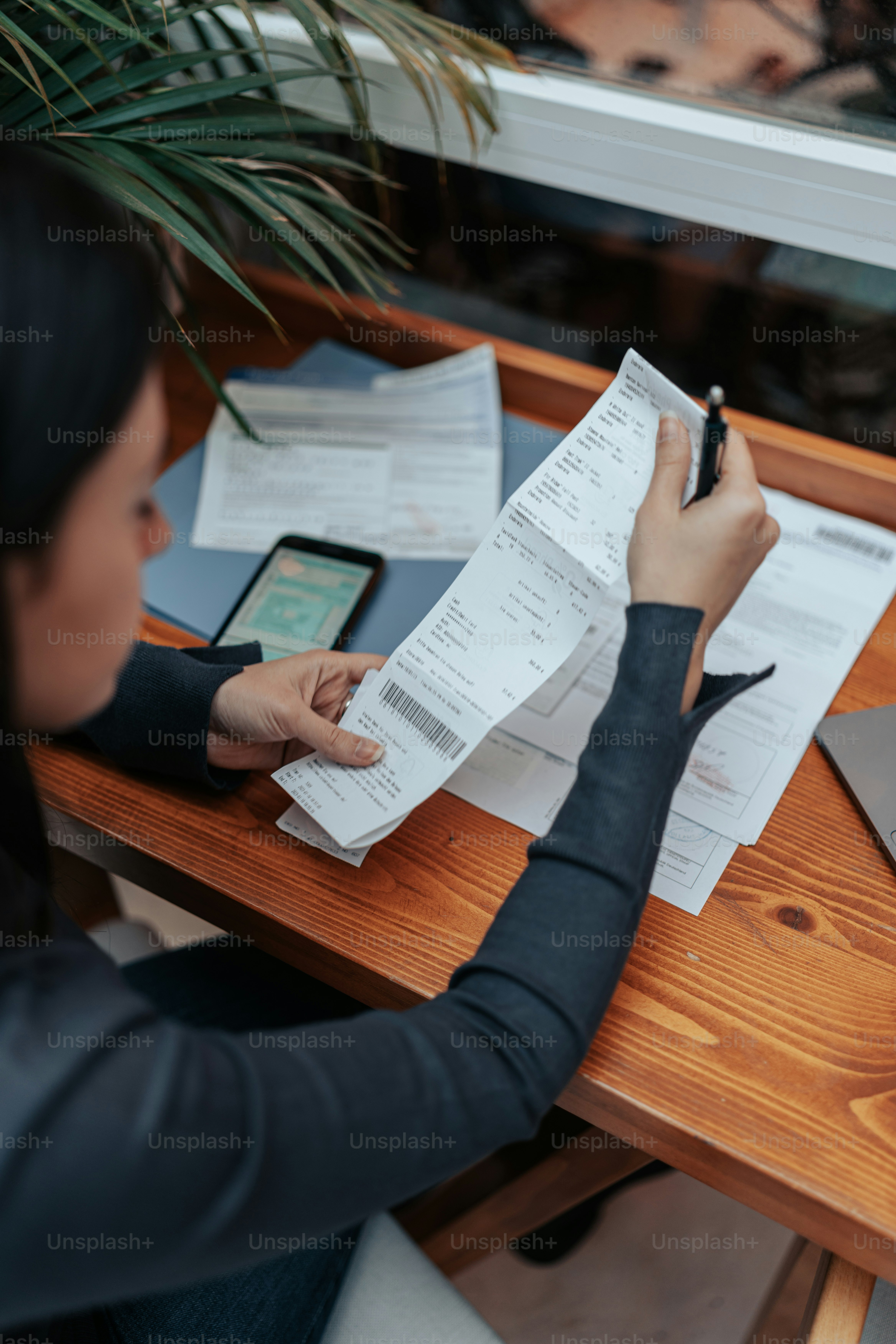 a woman sitting at a table writing on a piece of paper