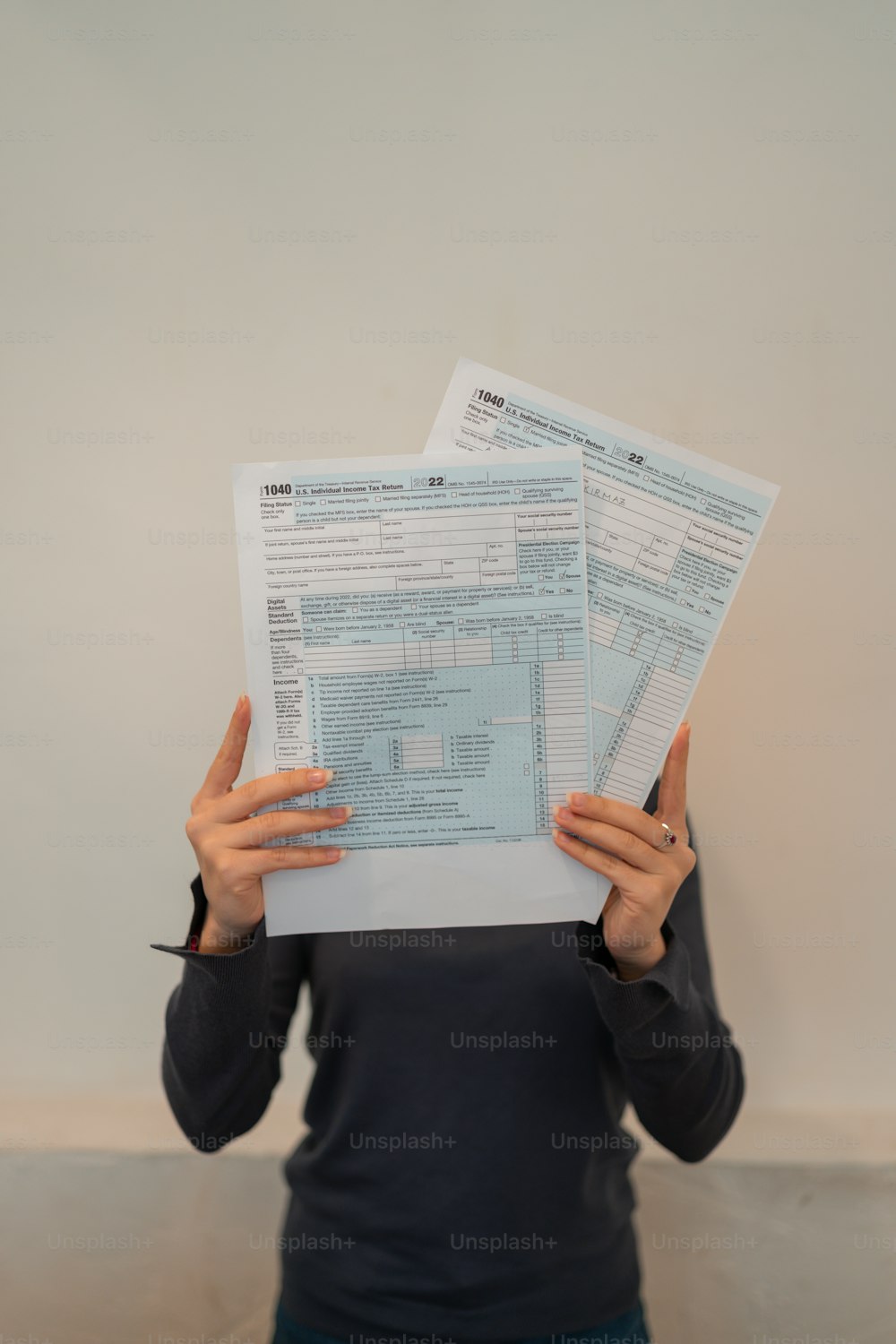 a woman holding two papers in front of her face