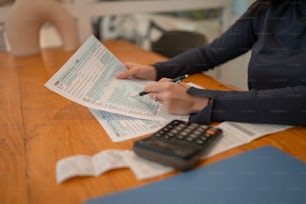 une personne assise à une table avec une calculatrice et un papier
