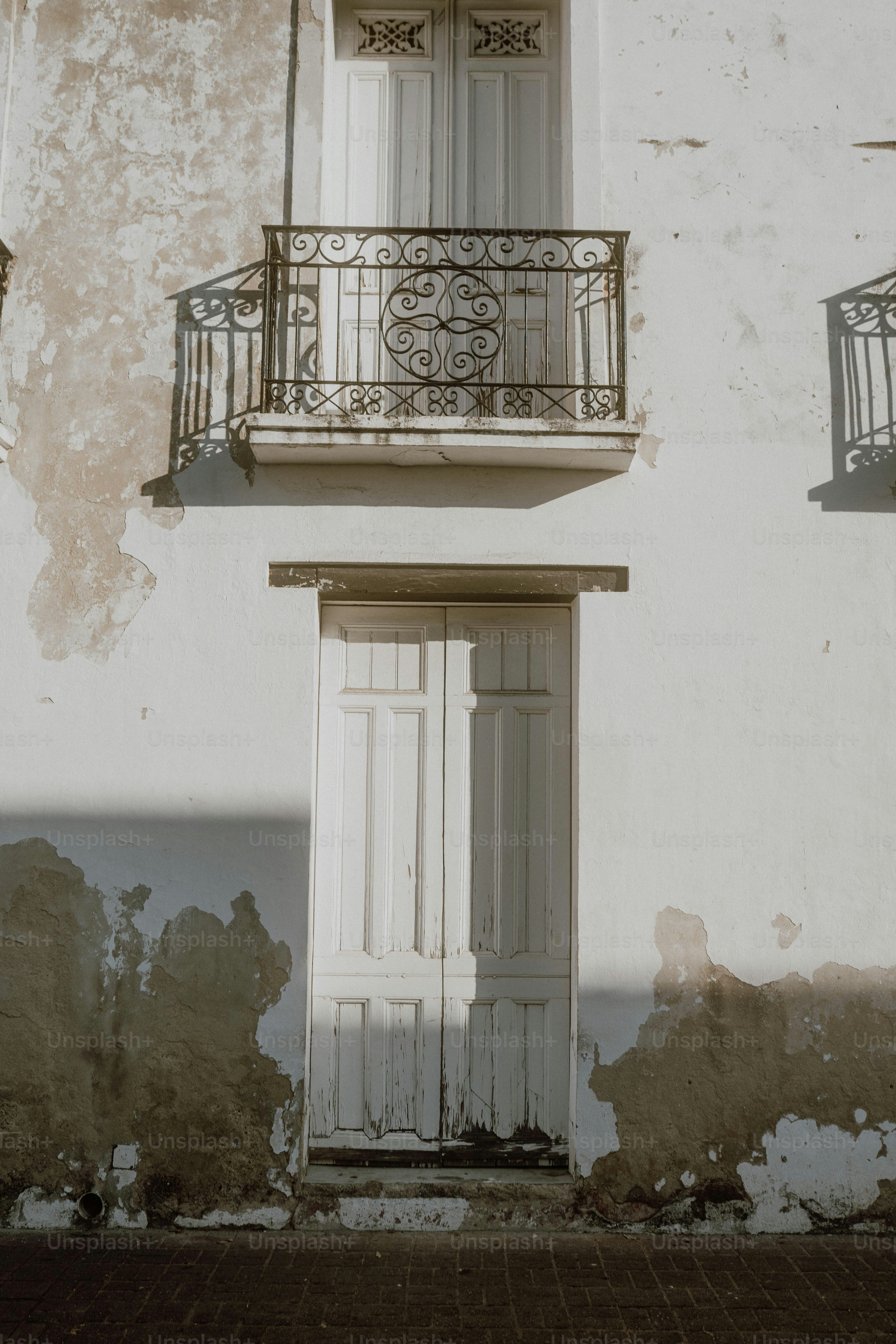 a white building with a balcony and a white door