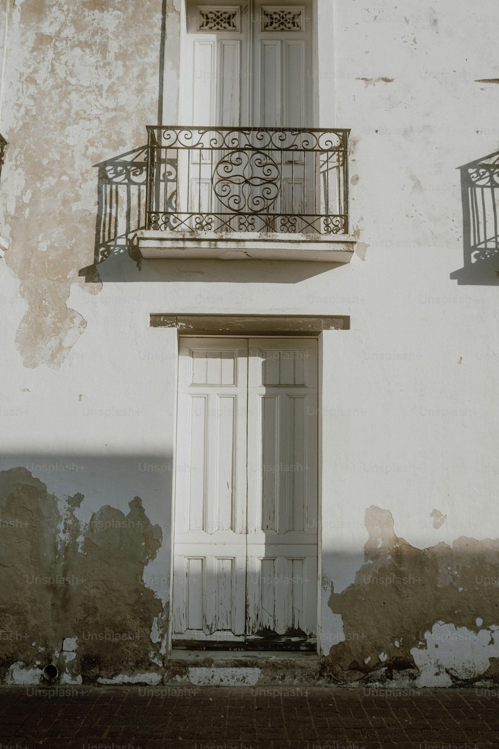 a white building with a balcony and a white door