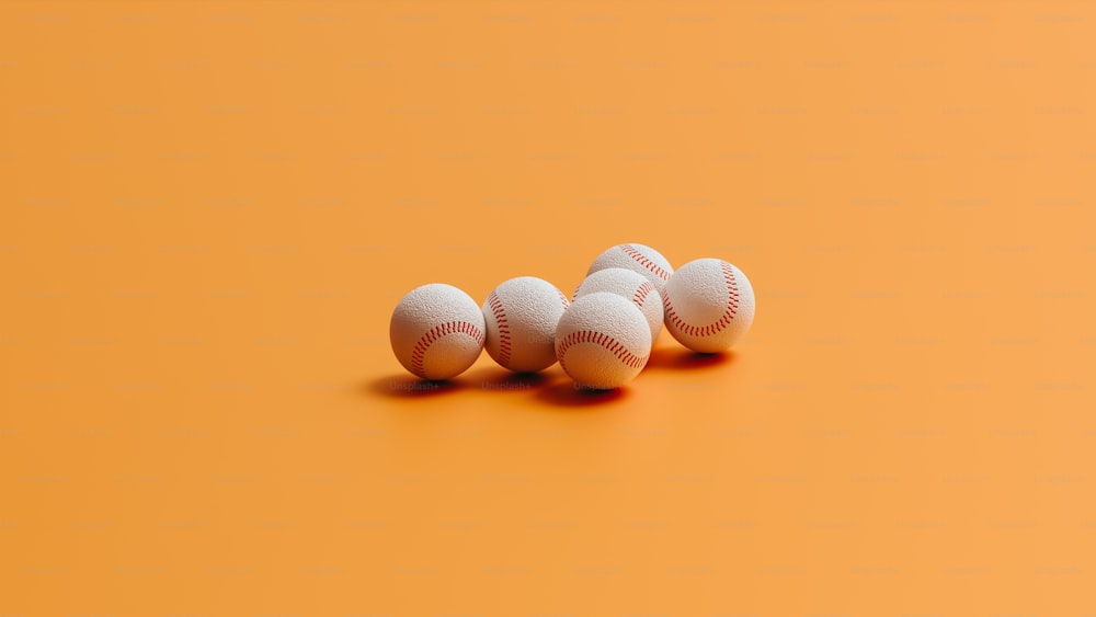 Un grupo de pelotas de béisbol sentadas encima de una superficie naranja