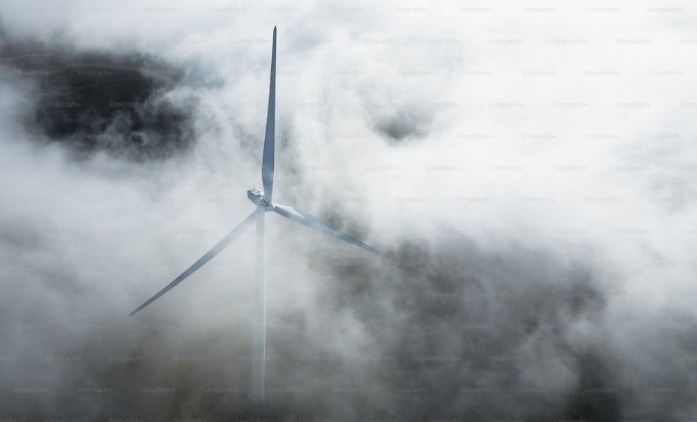 a wind turbine in the middle of a cloud filled sky