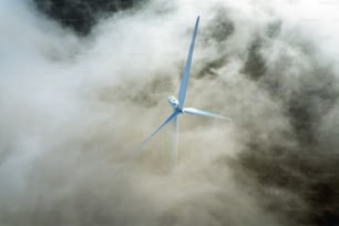 a wind turbine in the middle of a cloud filled sky