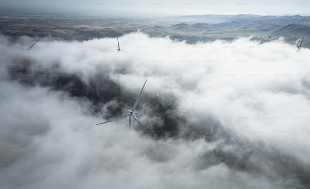 a group of windmills in the middle of a foggy field